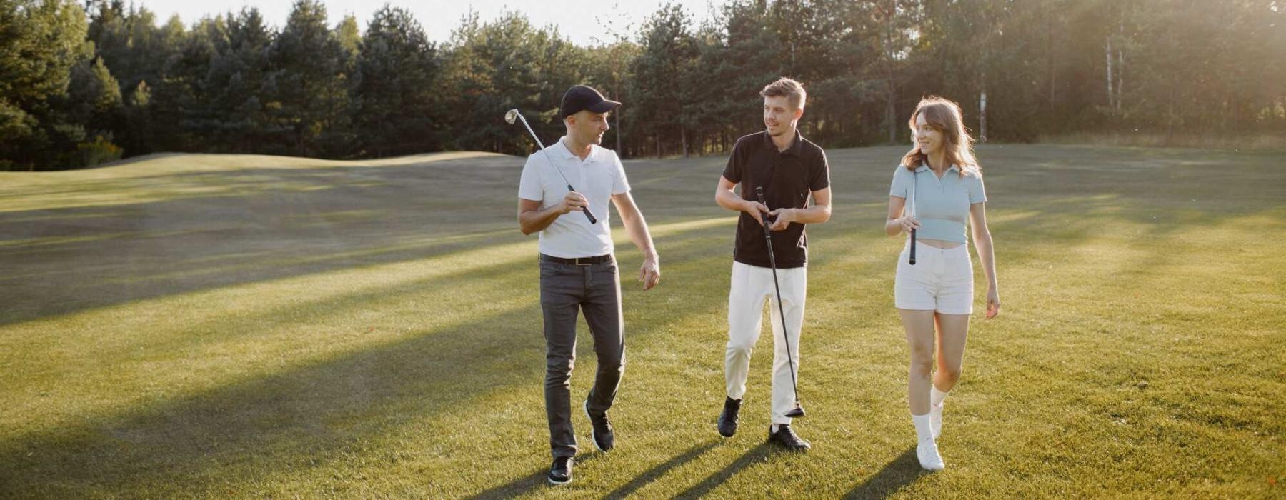 a group of people walking on a golf course