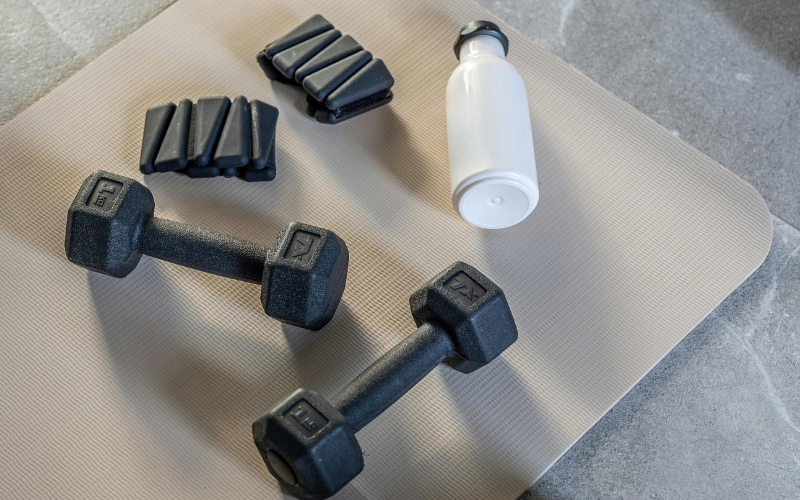 Fitness equipment arranged on a workout mat, highlighting opportunities for exercise and wellness.